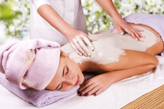 Young woman with slimming body thermal mask on her back. Spa Treatment.